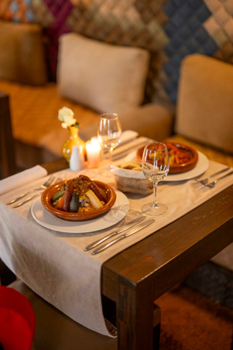 Traditional Moroccan couscous with lamb and vegetables served on a candlelit table at the Almaha Marrakech Pixel Restaurant