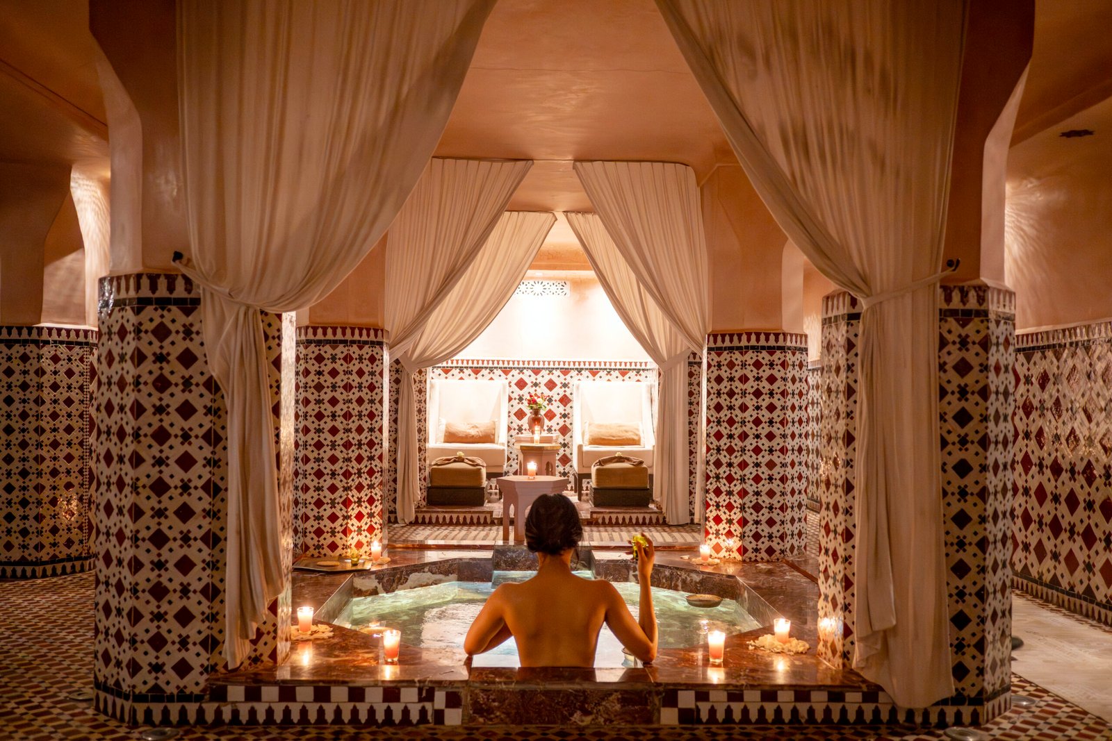 Traditional hammam pool with Moroccan zellige tiles and candles at Les Bains Almaha spa Marrakech