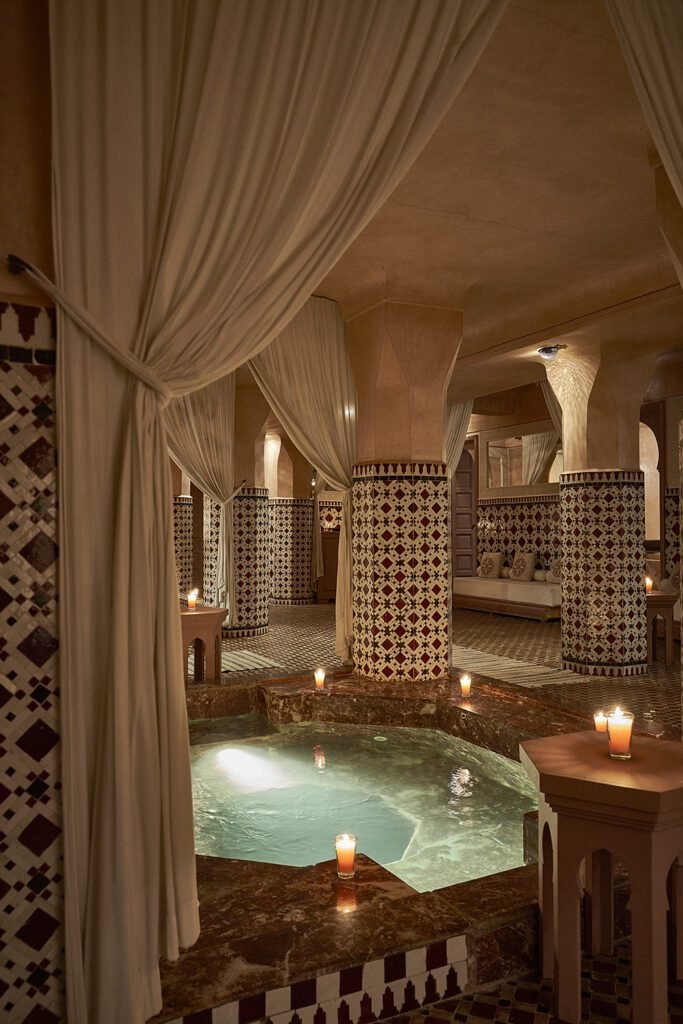 Candlelit spa area with zellige columns and marble pool at Les Bains Almaha Marrakech