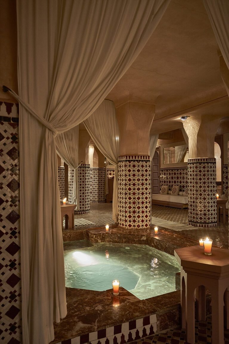 Candlelit spa area with zellige columns and marble pool at Les Bains Almaha Marrakech
